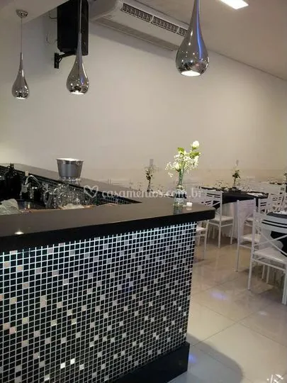 Balcão de bar revestido em pastilhas com pendentes cromados e balde de gelo
