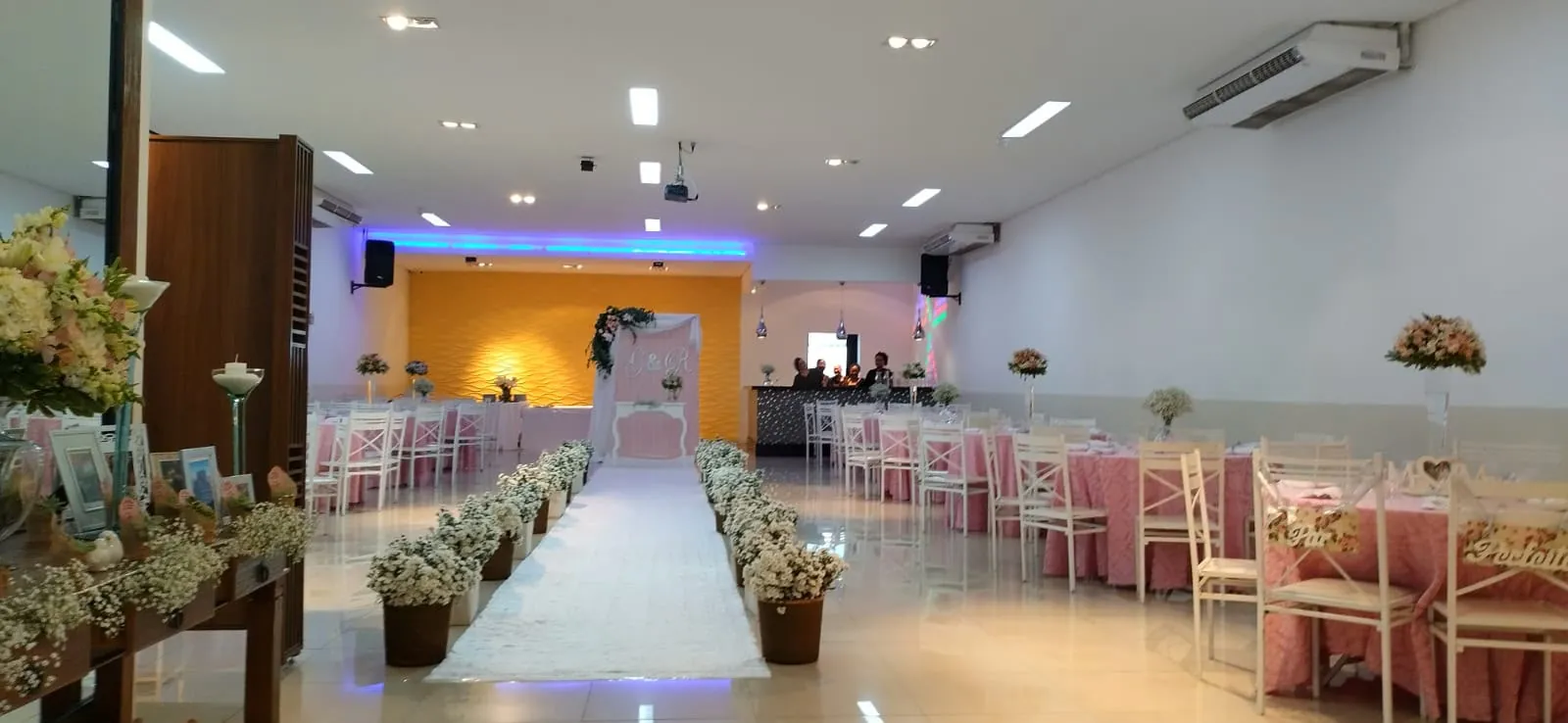 Salão Sandra Maria montado para casamento, com mesas postas, passarela e decoração em rosa